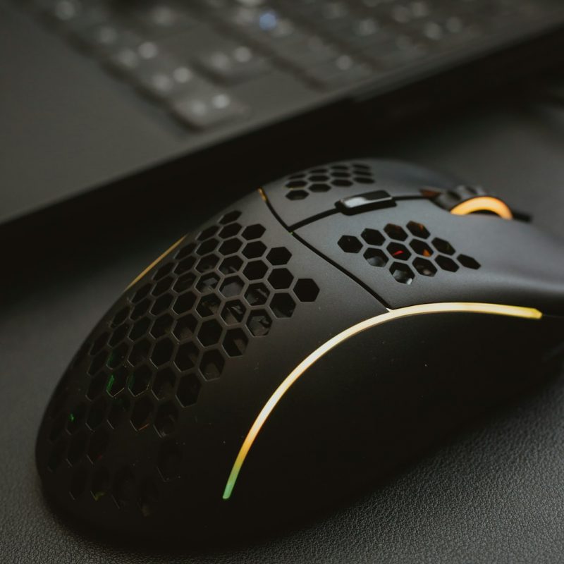 Gaming mouse on RGB mouse pad Black gaming mouse with RGB lighting on mouse pad in front of keyboard